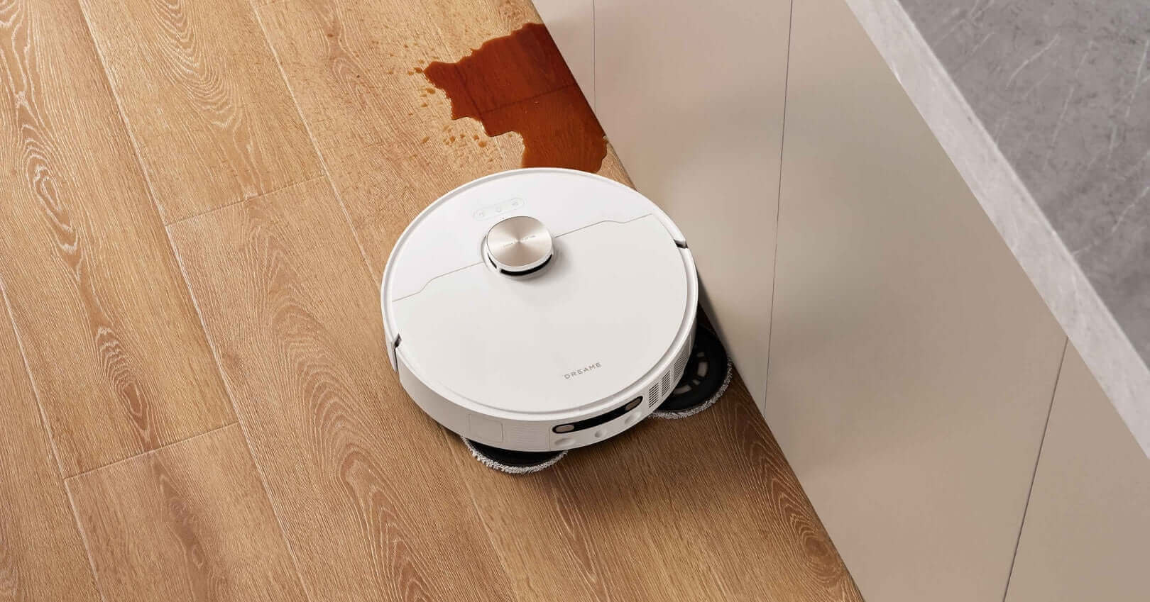 Moppaava robotti-imuri siivoaa läikkiä puulattialla keittiössä.