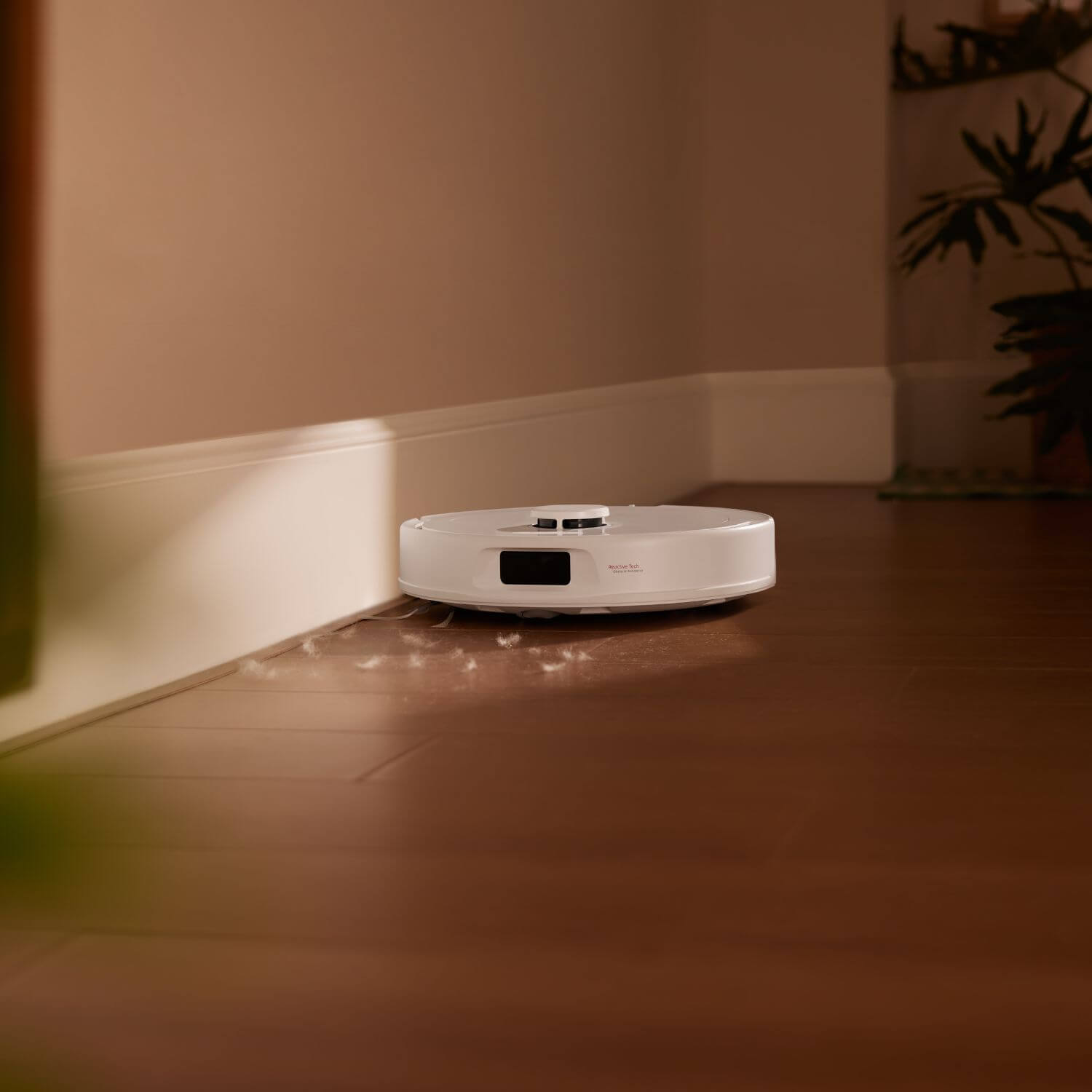 Roborock QR 798 robotti-imuri & -moppi siivoaa lattiapintaa nurkassa.